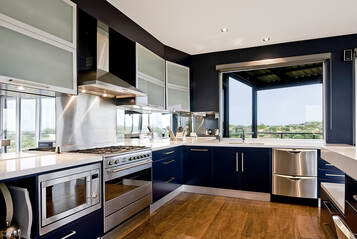 Picture of a blue appliance and counter top kitchen. looks very modern.