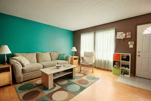 a picture of a turquoise colored wall with brown couch and brown coffee table.